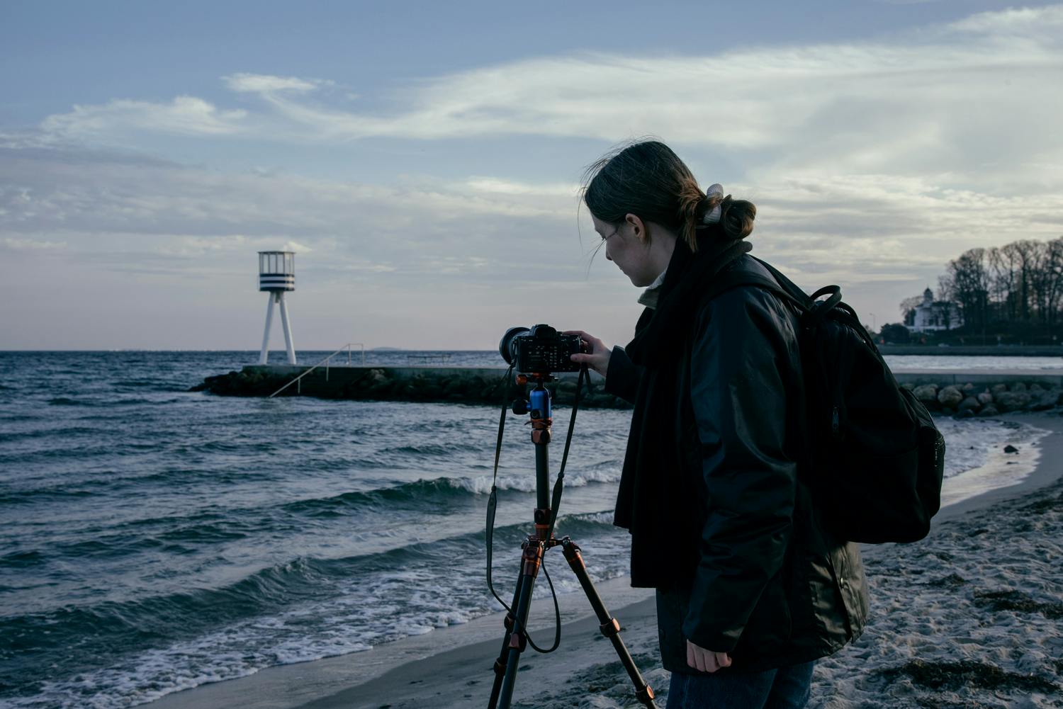 Bild av strand med fotograf ocj kamera på kamerastativ